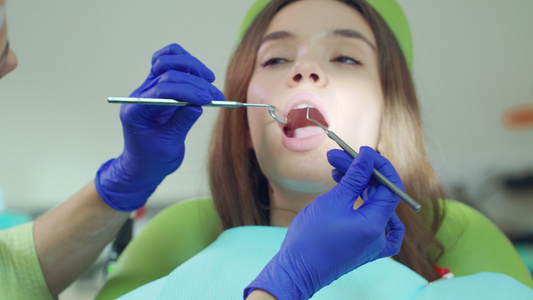 使用牙科工具检查病人牙齿的女医视频