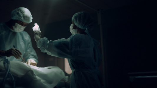 在黑暗的急诊室进行手术的专业外科医生视频