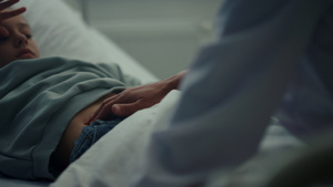 生病的孩子躺在床上医生在急诊病房特写检查病人的胃10秒视频