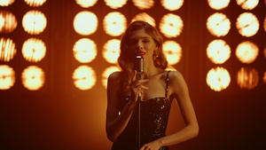 女性歌手表演歌曲在灯光下看着镜头10秒视频