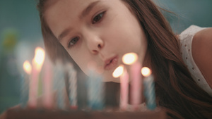 漂亮女孩在生日蛋糕上吹蜡烛火焰 慢动作18秒视频