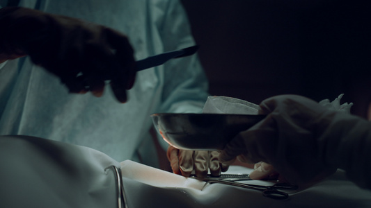 外科医生手在黑暗的医院病房里用手术刀做切口视频