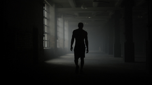 运动员在锻炼后休息走在黑暗的走廊剪影视频