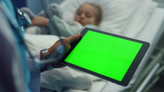 医生手拿着绿屏平板电脑设备在医院病房特写视频