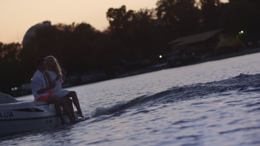 日落时坐在漂浮机动船上的年轻人视频