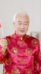 穿中国装扮的爷爷挥舞红旗视频