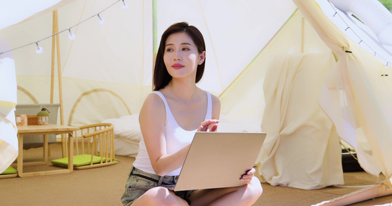 女孩坐帐篷里使用电脑视频
