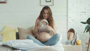 怀孕孕妈在家里给肚子里的宝宝进行音乐胎教14秒视频