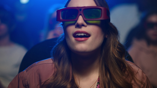 年轻女孩在电影院带着3d眼镜观看震撼特效视频