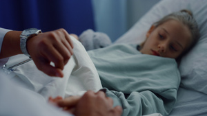 医生手手动检查躺在病床上的小女孩身体状况体检11秒视频