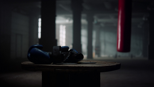 蓝色拳击手套躺在健身房的木箱上视频