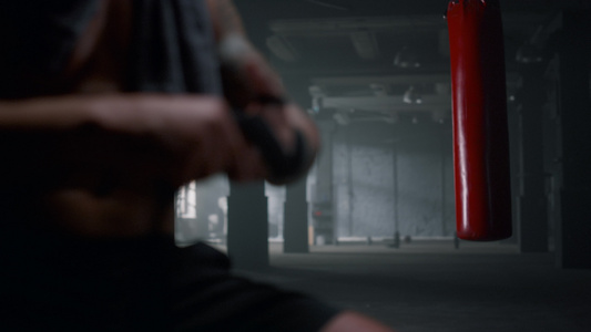 拳击手在健身房里用拳击胶带包住双手视频