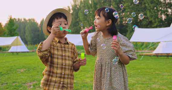 两个小孩在草地上吹泡泡视频