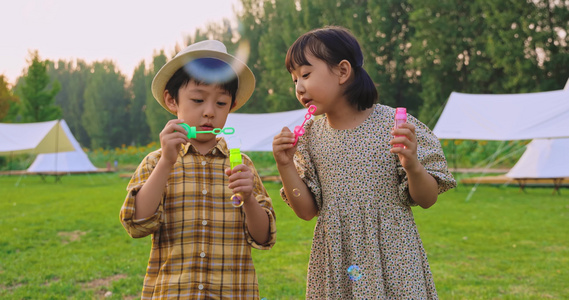 两个小孩在草地上吹泡泡视频