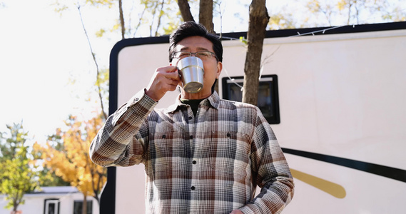 老年男人站在房车露营院子里喝咖啡视频