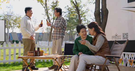 中老年人在房车露营地喝啤酒聊天看手机视频视频
