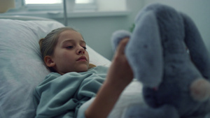 心烦意乱的女孩躺在医院病床上独自玩毛绒玩具11秒视频