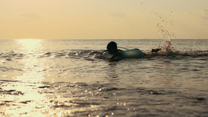 孩子在大海里游泳夕阳下剪影17秒视频
