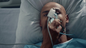 病人戴上氧气面罩躺在床上特写手指上的脉搏血氧仪20秒视频