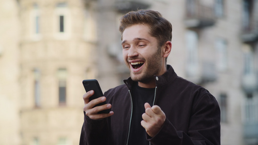 男性在户外读手机信息表情欣喜视频