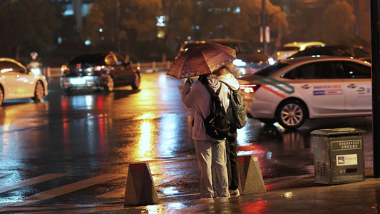 雨夜撑伞过马路的情侣视频