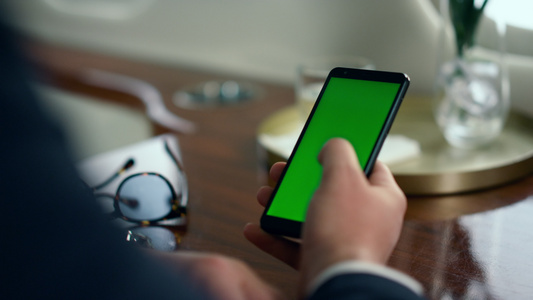 男性白领手刷绿色智能手机屏幕特写视频