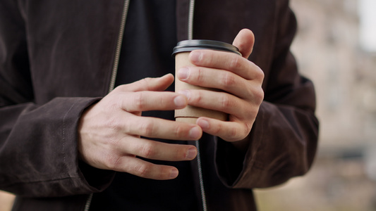 冬天户外年轻男性手握热咖啡特写视频