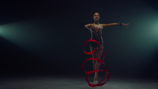 艺术体操女子运动员旋转体操丝带展示技巧视频