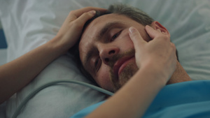疲惫的病人在手术治疗特写后躺在床上家人的手摸脸13秒视频