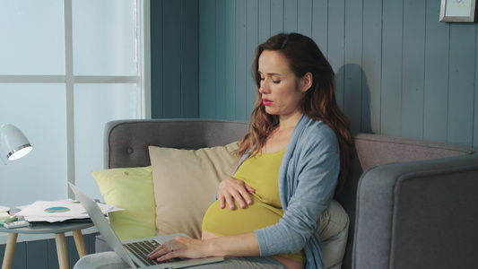 孕妇摸着肚子无奈着工作视频