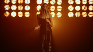 优雅金发女歌手在聚光灯下表演独家歌曲8秒视频