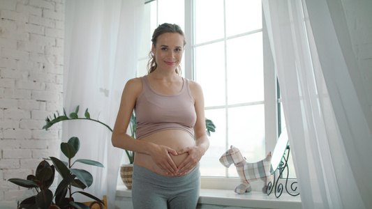 孕妇在窗前抚摸自己的肚子视频