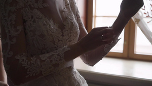 新娘在她的婚纱上扣上袖子8秒视频