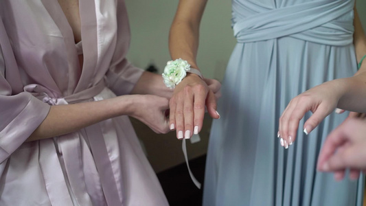 年轻新娘给伴娘手腕戴上鲜花手镯视频