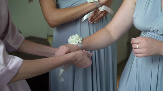 年轻新娘给伴娘手腕戴上鲜花手镯视频