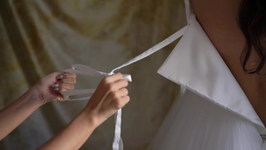 帮助年轻新娘穿上结婚礼服的伴娘奢华的婚纱6秒视频