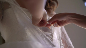 帮助年轻新娘穿上结婚礼服的伴娘12秒视频