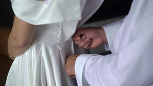 帮助年轻新娘穿上结婚礼服的伴娘奢华的婚纱8秒视频