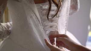 帮助年轻新娘穿上结婚礼服15秒视频