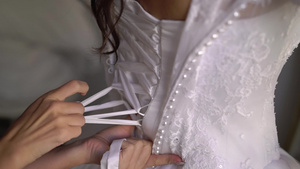 帮助年轻新娘穿上结婚礼服的伴娘7秒视频