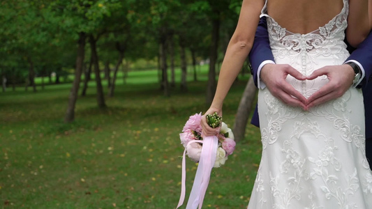 新郎在怀着新娘的双臂时做一个心牌视频