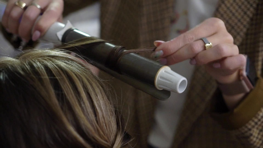 理发师为新娘做头发一个年轻女孩的婚礼发型做头发造型视频