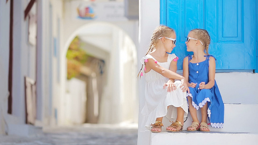 两个穿着蓝色连衣裙的女孩在户外玩得开心希腊米科诺斯视频