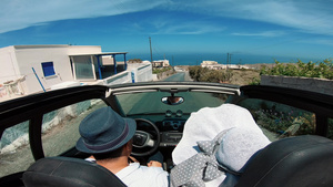 在桑托里尼岛海岸驾驶敞篷轿车的一对快乐的年轻夫妇在30秒视频