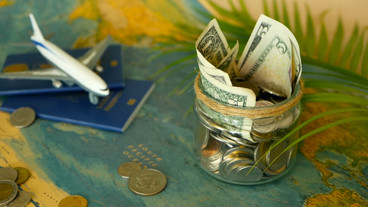 旅行预算概念在世界地图背景的玻璃罐中为假期节省的钱视频