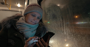 妇女冬季晚上乘坐公共汽车时使用手机的妇女人数8秒视频