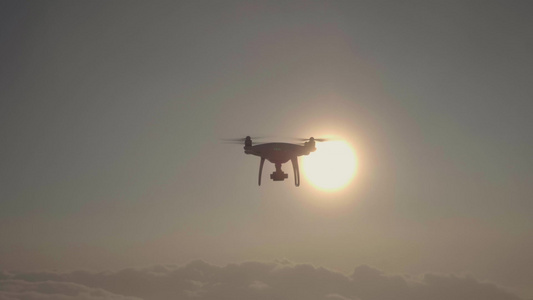 无人驾驶飞机飞向云层的右侧重叠太阳空中观察慢动作视频