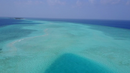 蓝绿海白沙背景下异域湾海滩航行的无人机空中景观视频