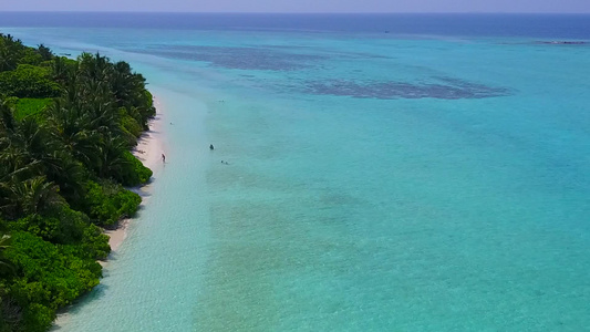 水蓝色海洋和白色沙滩背景下完美度假海滩度假的无人机视频
