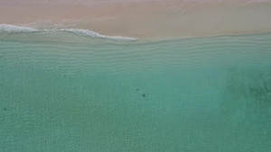 以白色沙子背景的绿绿水为目的无人驾驶飞机在海边巡视12秒视频